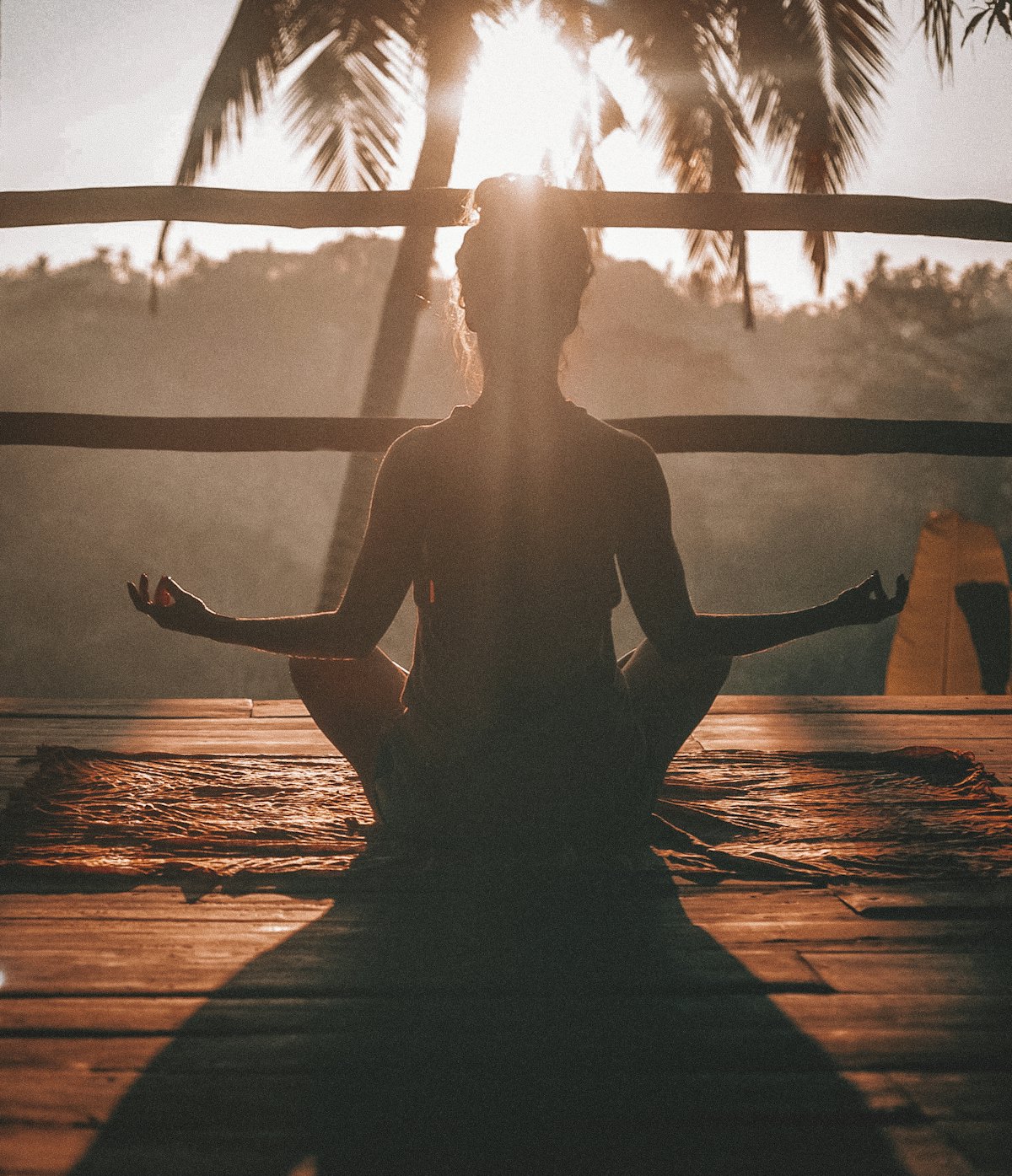 A figure meditating in lotus at golden hour — contemplative practice.